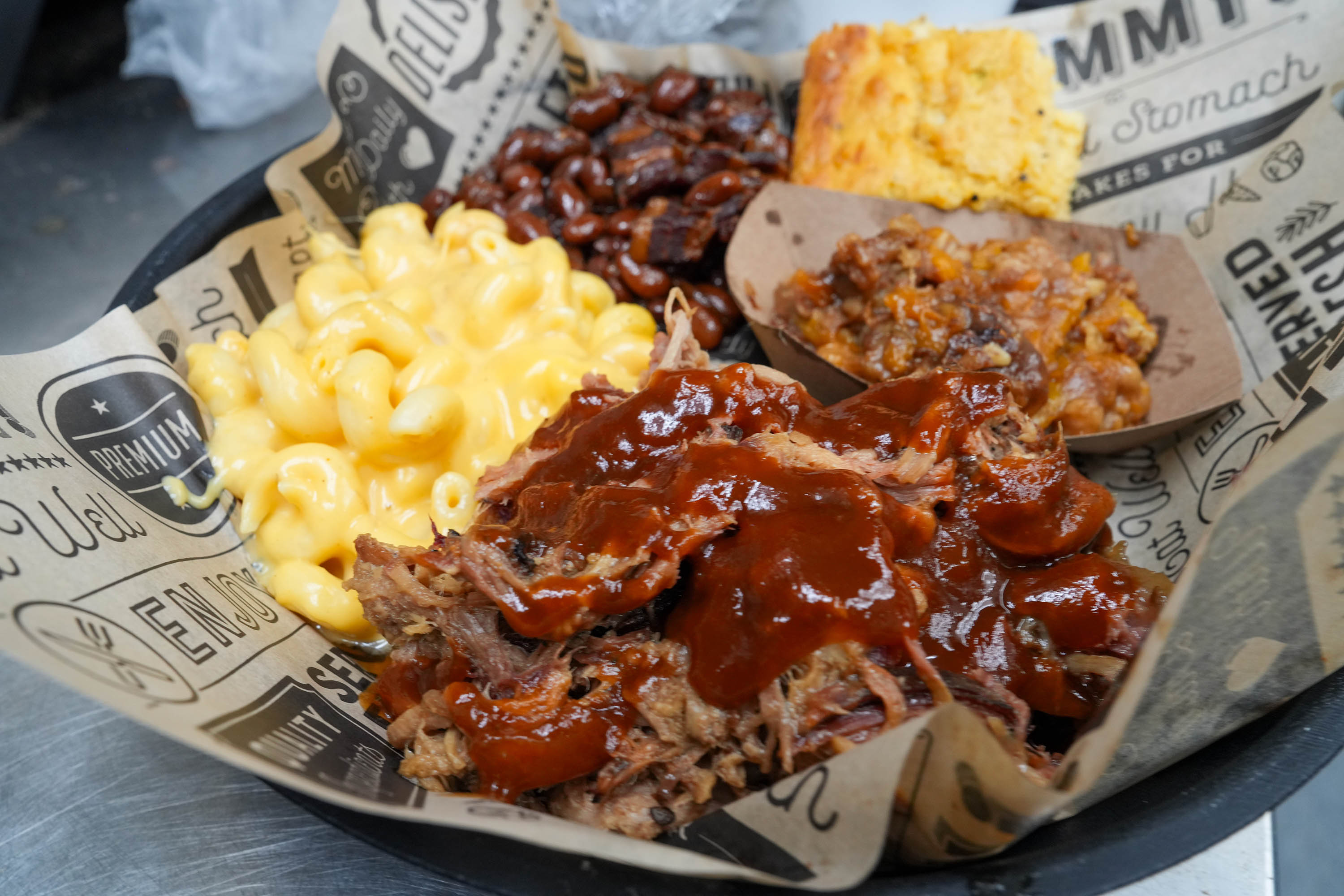 Pulled pork plate with smoked mac and cheese, baked beans, cornbread, and cobbler