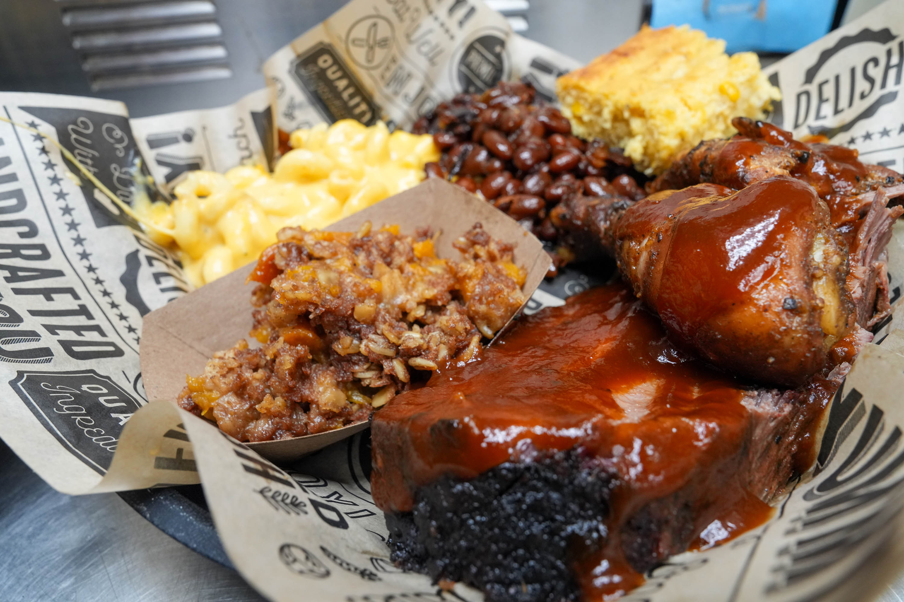 Barbecue plate with ribs, chicken, mac and cheese, beans, cornbread, and cobbler